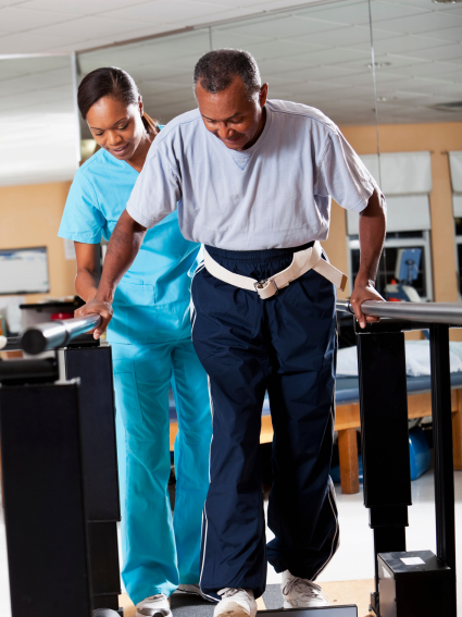 Physical Therapist assisting older adult patient