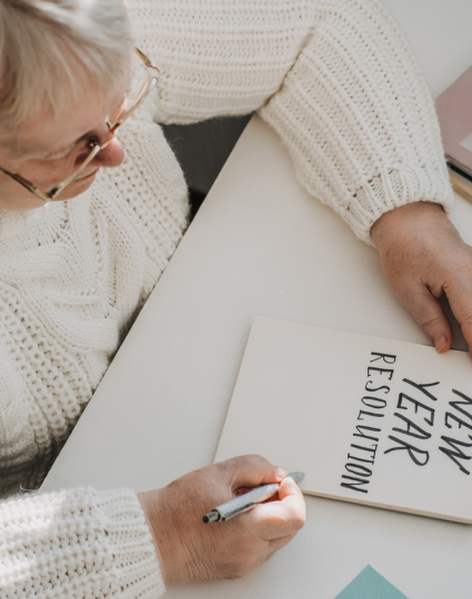 Older adult woman writing her New Year's resolutions