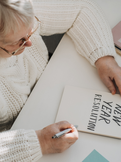 Older adult woman writing her New Year's resolutions